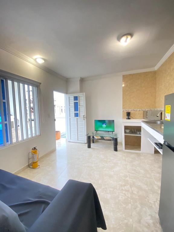a large living room with a kitchen and a tv at Cartagena Visible Casa de Huéspedes in Cartagena de Indias