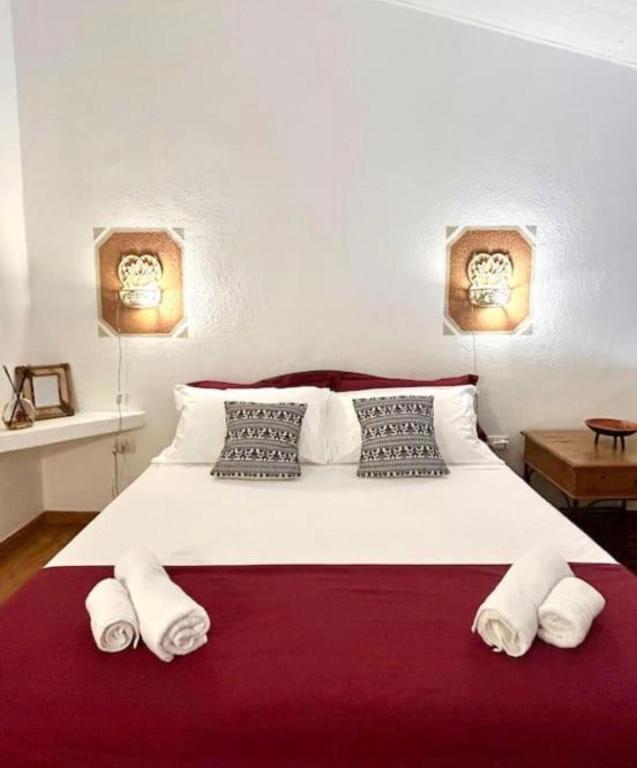 a bedroom with a large white bed with two pillows at NURAS - Gioberti Charme House in Alghero