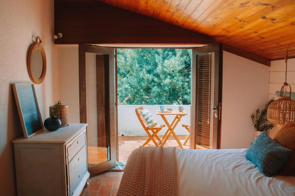 a bedroom with a bed and a view of a patio at Casa com 4 quartos e Jardim Espaçoso - Santa Sofia in Moledo