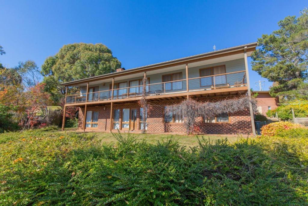 a large brick building on a hill with trees at Winterwood 9 Camira Ave in Jindabyne