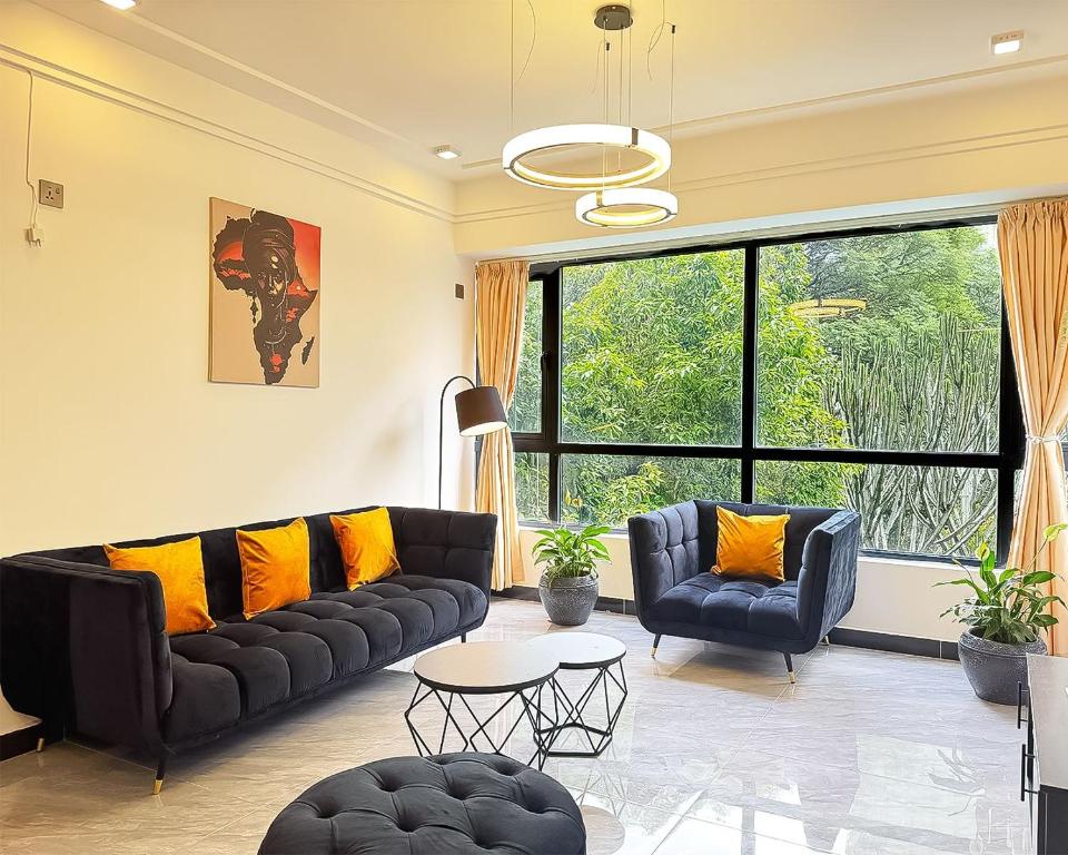 a living room with black leather couches and yellow pillows at Neptune Luxe in Nairobi