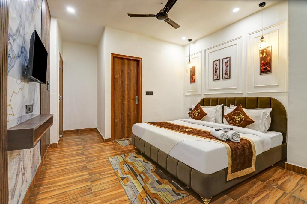 a bedroom with a large bed and a television at Hotel The Arrow International Laxmi Nagar in New Delhi