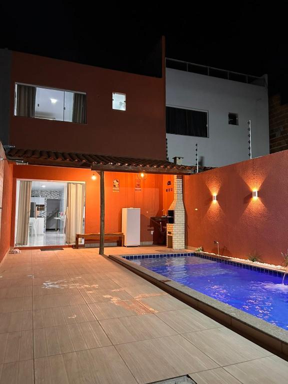 a swimming pool in front of a house at night at Casa com piscina em Jauá in Camaçari