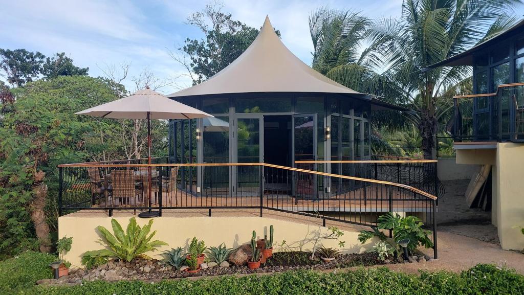 a house with a white roof and an umbrella at The Halfway Cafe-Dauin, Glamp2 - Grasshopper in Dauin