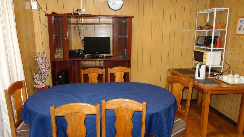a dining room with a blue table and chairs at casa completa Balmaceda 77 in Concepción