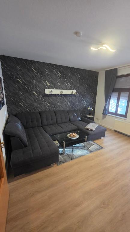 a living room with a black couch and a table at Suite Calli in Bernburg
