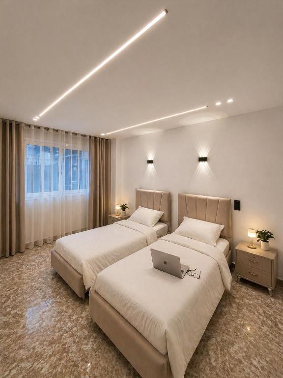 two beds in a hotel room with a laptop on the bed at Dar Essalam - Mostaganem, Salamandre in Mostaganem