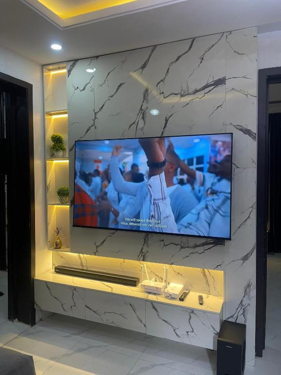 a flat screen tv on a stone wall at Luxury home in Lagos