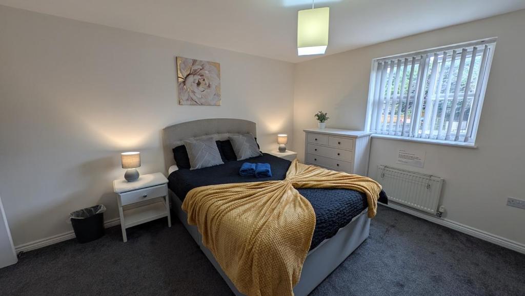 a bedroom with a bed and two night stands and a window at Large Modern House With Private Parking in Heeley