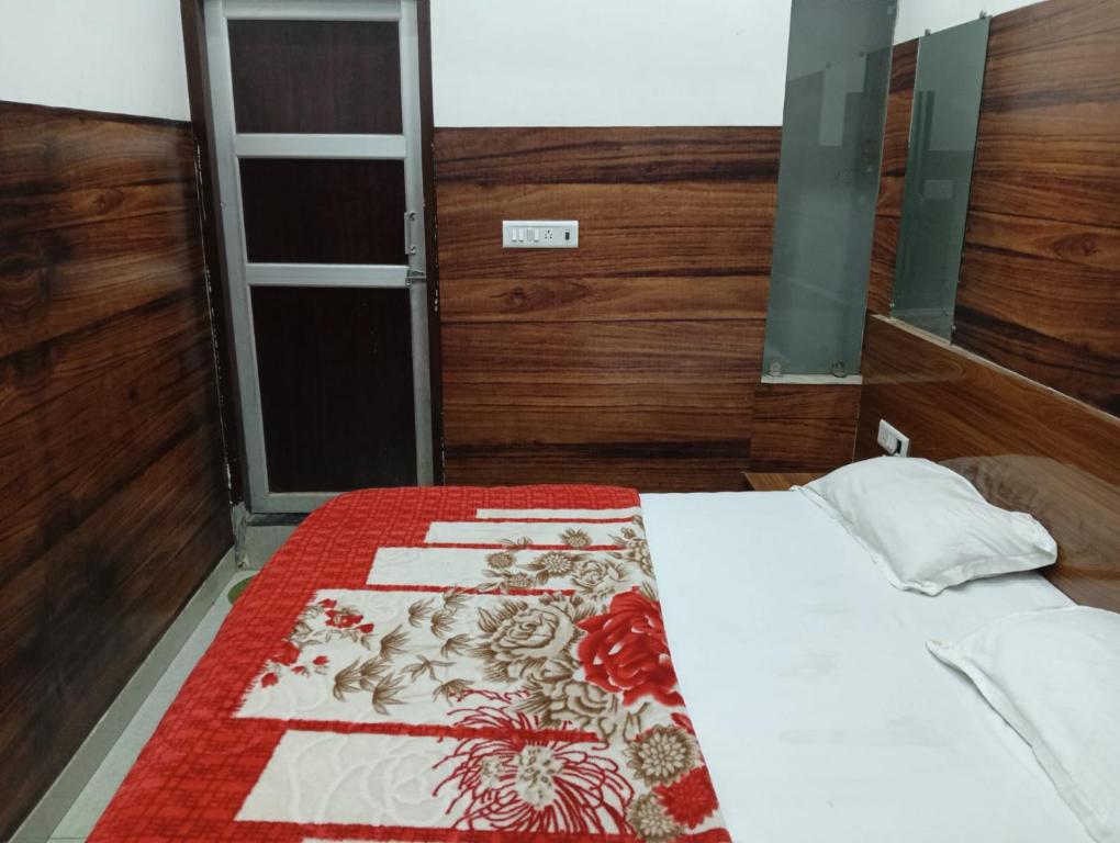 a bed with a red and white blanket on it at Well come hotel in Baori Thikria