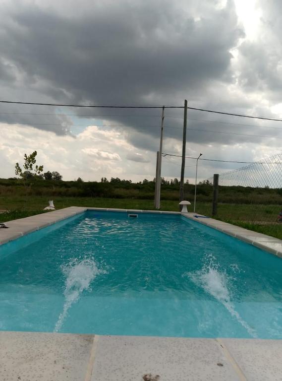 a blue swimming pool with a fence in a field at Rincón Entrerriano in Concepción del Uruguay