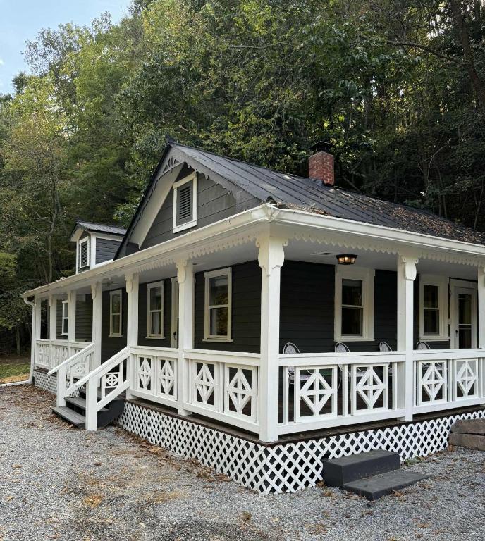 a black and white house with a white porch at The Renovated Farmhouse at Seneca Rocks in Seneca Rocks