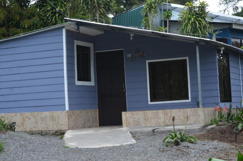 a blue house with a black door at Hummingbird Morfus Lodge in Tilarán