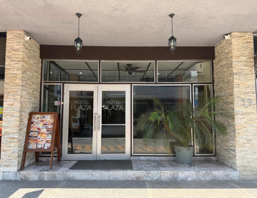 a building with glass doors and a plant in front at Hotel Plaza in Tuxpan de Rodríguez Cano