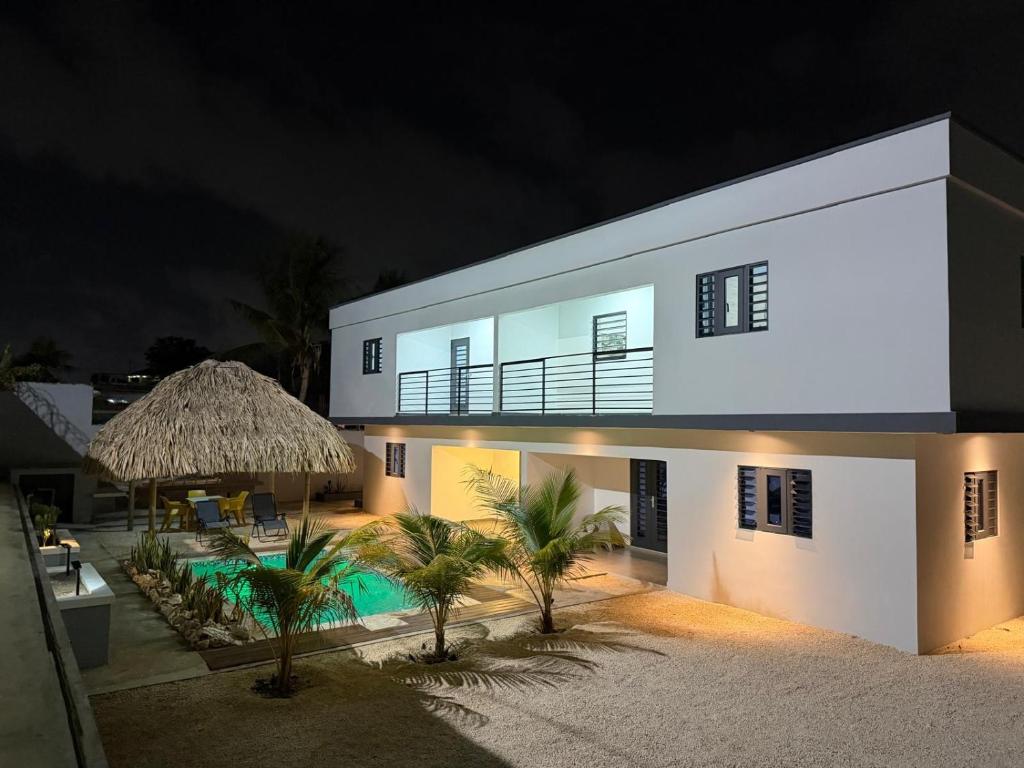 a large white building with a swimming pool at night at Blanquila Resort in Willemstad