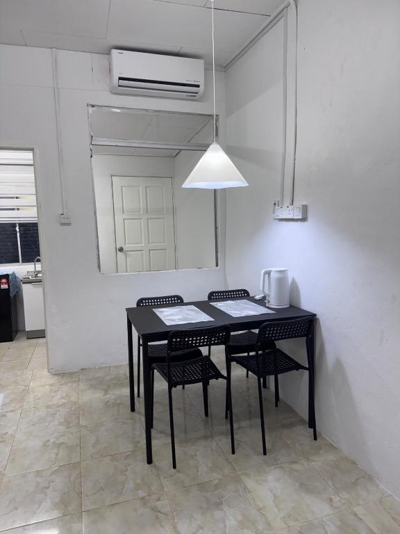 a dining room with a black table and chairs at DNH Nilam Puri Homestay Unit C in Kota Bharu