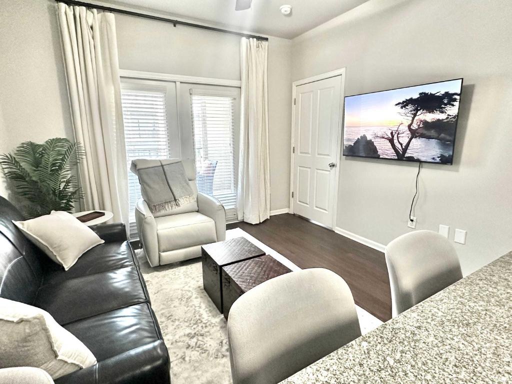 a living room with a black leather couch and chair at Walk to Stadium & Cotton District, Balcony & Pool in Starkville