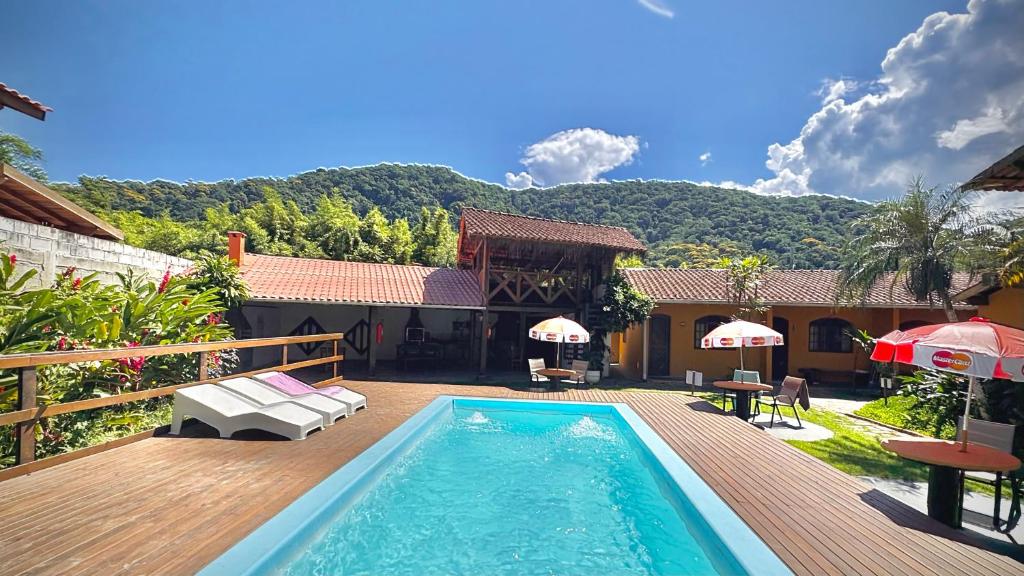 a house with a swimming pool in the yard at Chalés Água de Coco in Boicucanga