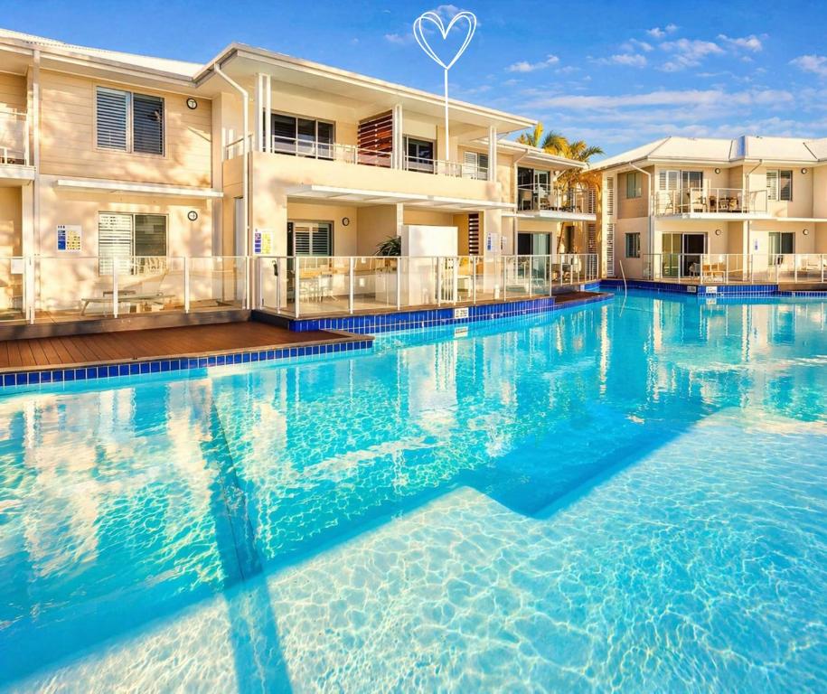 a large swimming pool in front of a building at Beautifully Restyled Studio Apartment - Oaks Pacific Blue - Sea Salt Escape in Salamander Bay