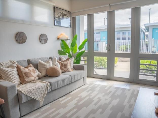 a living room with a gray couch and sliding glass doors at Villa Lua, Boqueron, Puerto Rico in Cabo Rojo