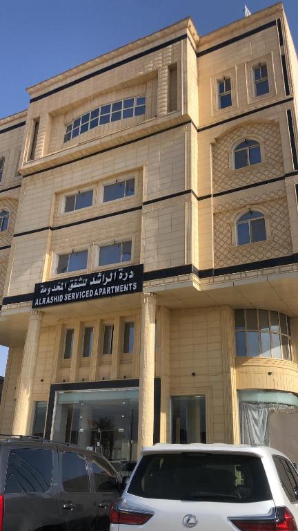 a building with cars parked in front of it at شقق درةراشد للشقق المخدومة in Hafr Al-Batin