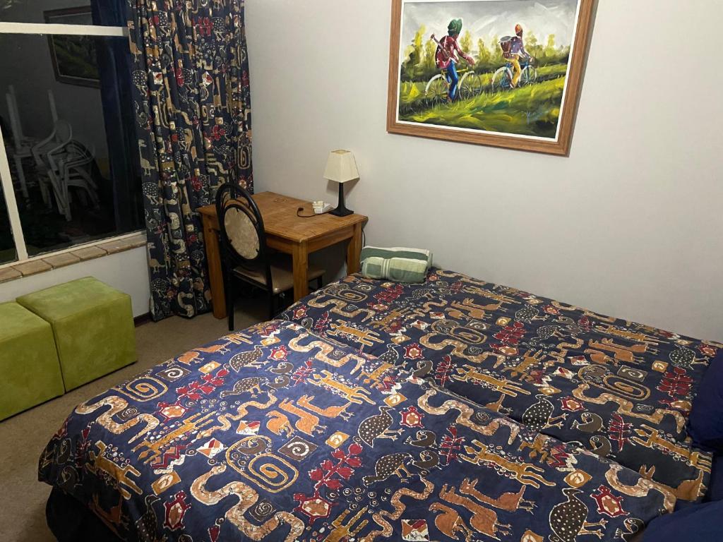 a bedroom with a bed with a colorful blanket at Highway Haven in Stilfontein