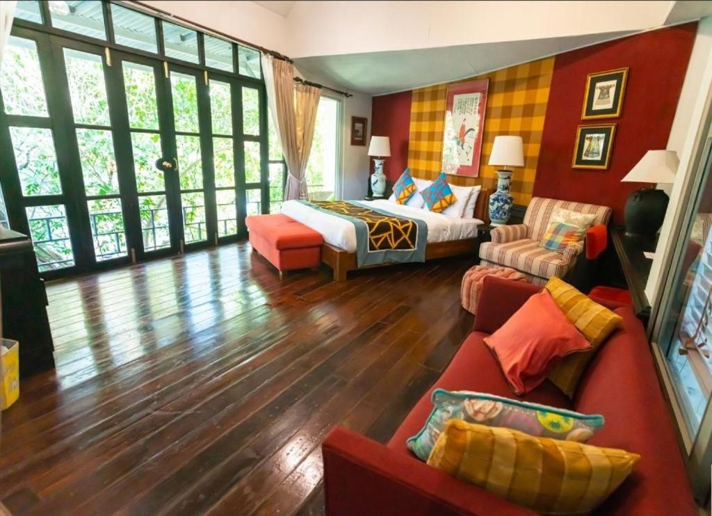 a living room with a bed and a couch at Zantiis Ndol Villas in Muak Lek District