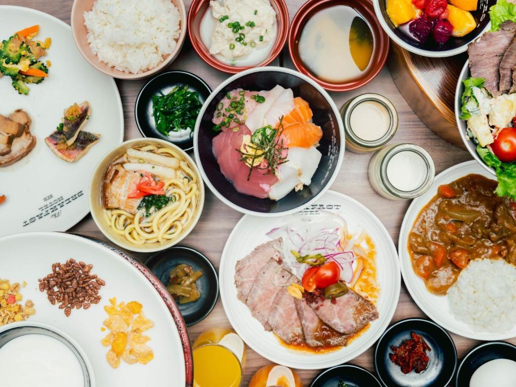 a table topped with plates of food and bowls of food at The BREAKFAST HOTEL PORTO Ishigakijima in Ishigaki Island