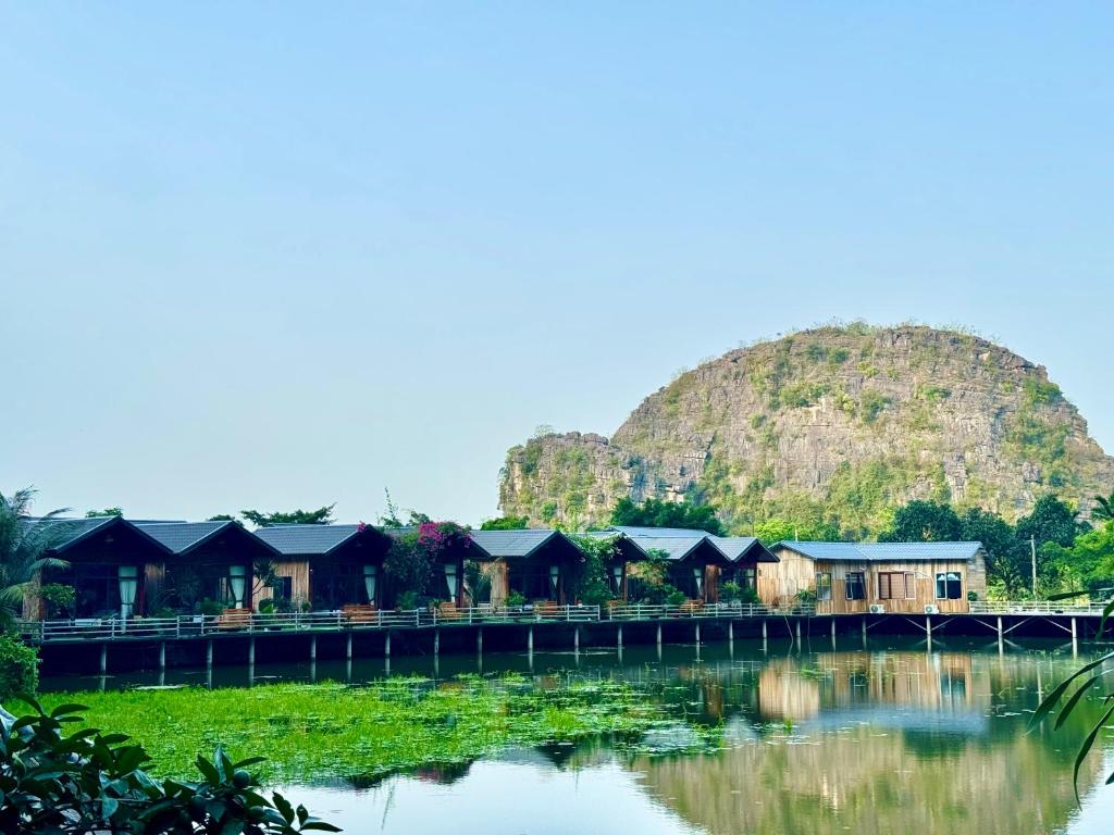 a row of houses in front of a mountain at Cham Trang An Retreat in Vũ Lâm