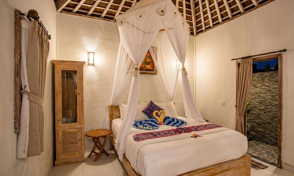 a bedroom with a bed with a canopy at Svaha Private Villas Ceningan in Nusa Lembongan