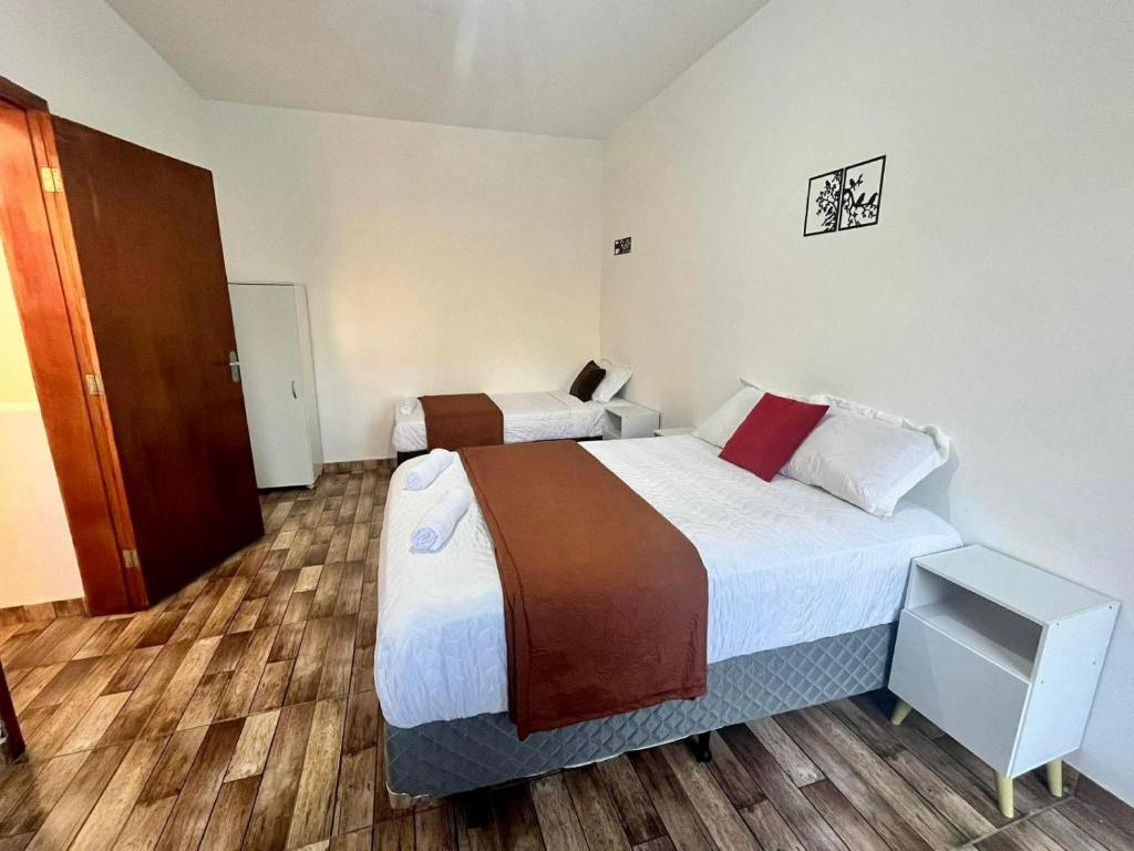 a hotel room with two beds and a closet at A Casa di Minas in Três Corações