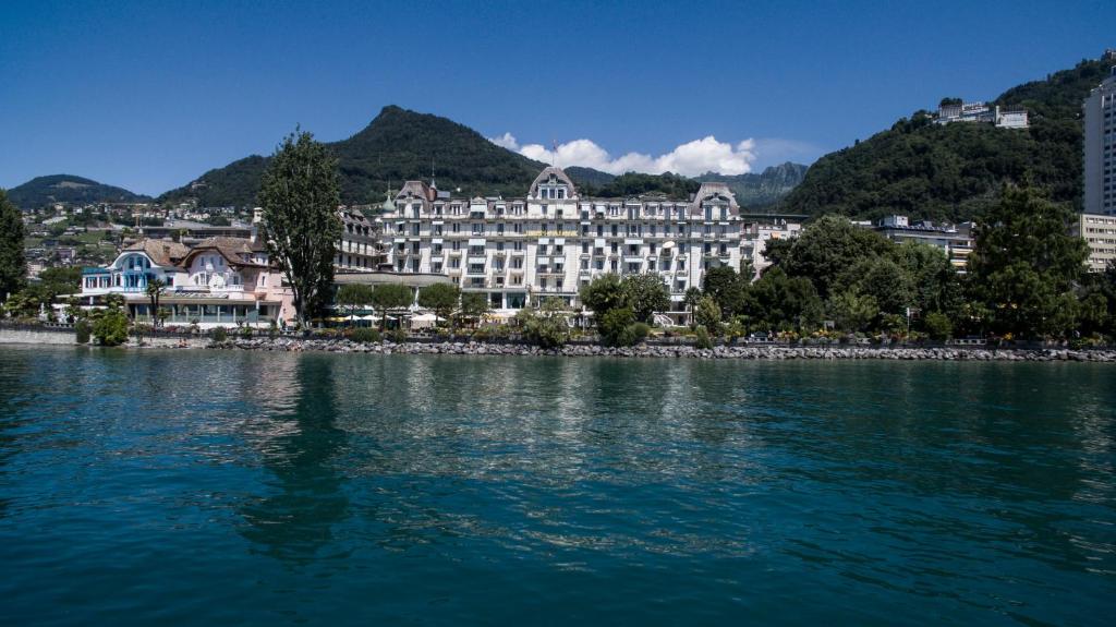 
a large body of water with buildings at Hotel Eden Palace au Lac in Montreux
