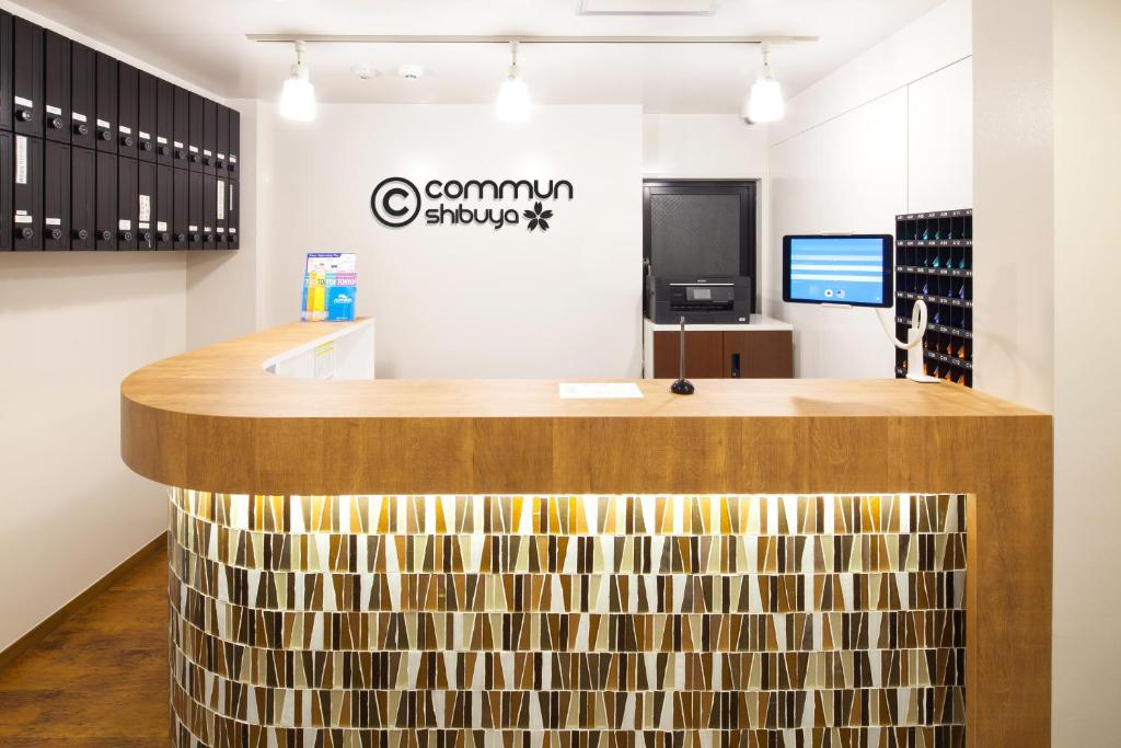 a bar in a wine shop with a wooden counter at commun SHIBUYA (Male Only) in Tokyo