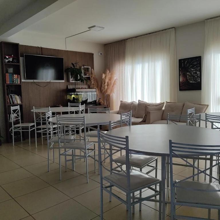 a living room with tables and chairs and a couch at Hotel Serrano in Inácio Martins