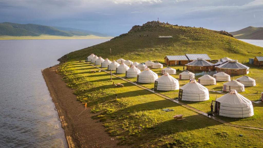 a row of tents on a hill next to a body of water at Maikhan Tolgoi lodge in Horgo