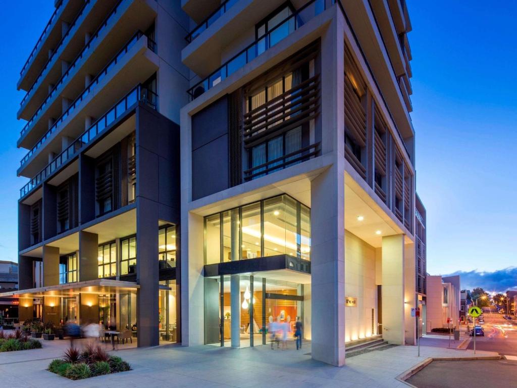 an office building with large windows at dusk at Novotel Newcastle Beach in Newcastle