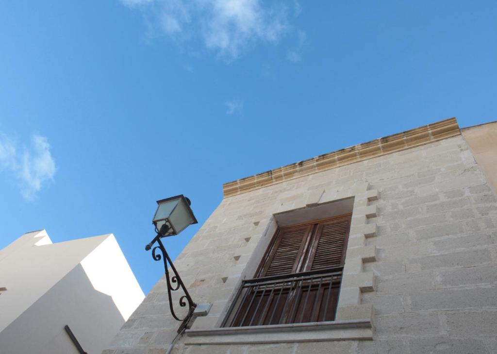 un bâtiment avec une fenêtre et une lumière de rue dans l'établissement B&b Il Tufo, à Favignana