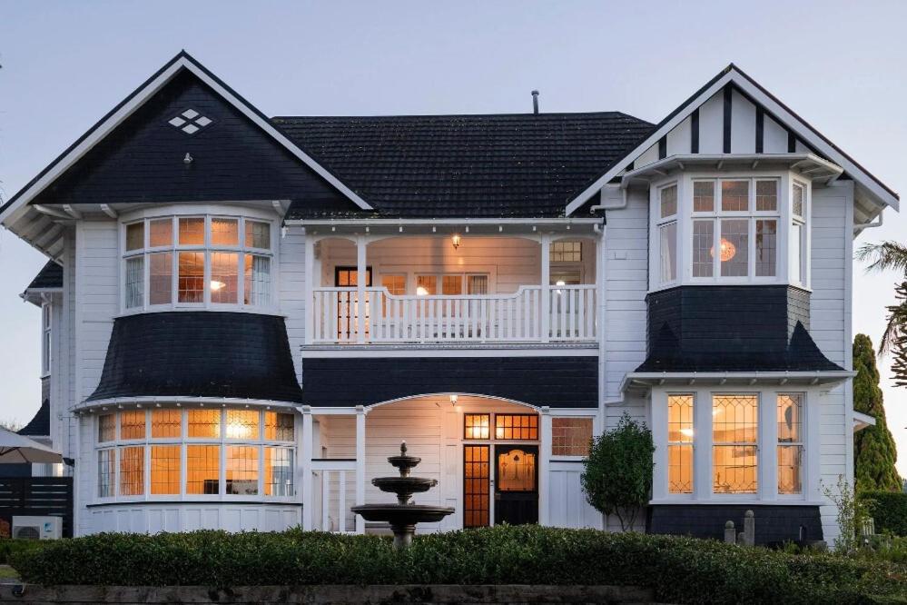 a large white house with a black roof at Cedar House in Gisborne