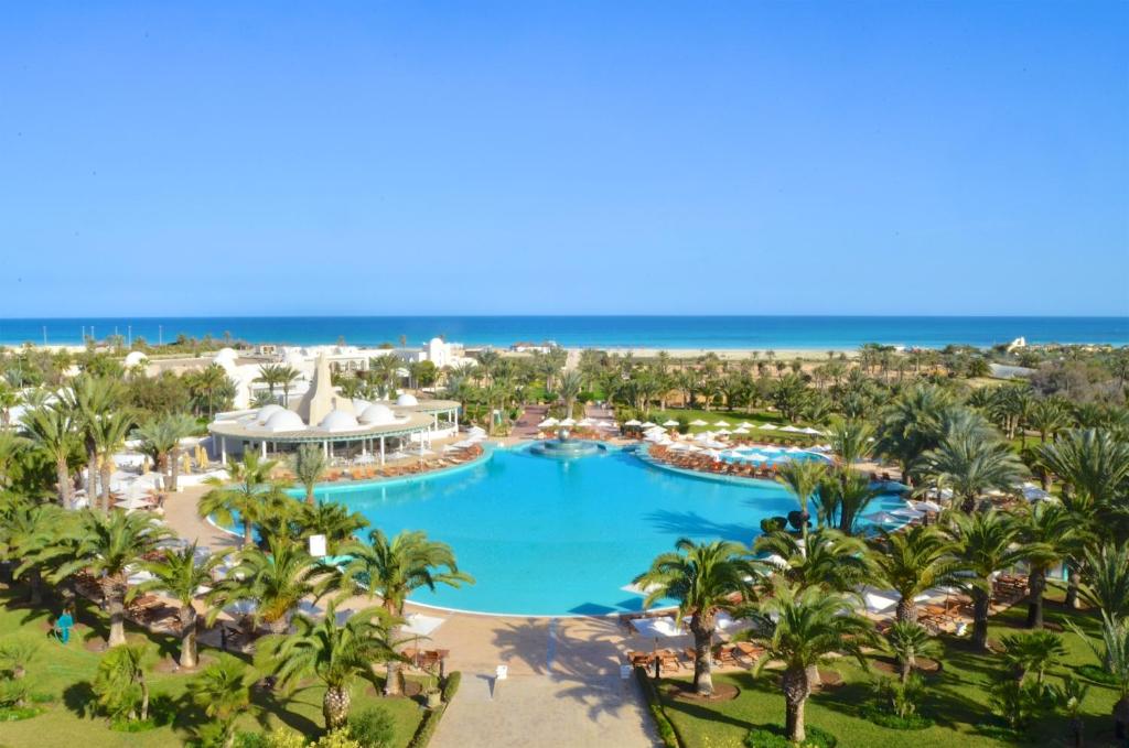 a beach with palm trees and palm trees at Royal Garden Palace - Families and Couples in Midoun