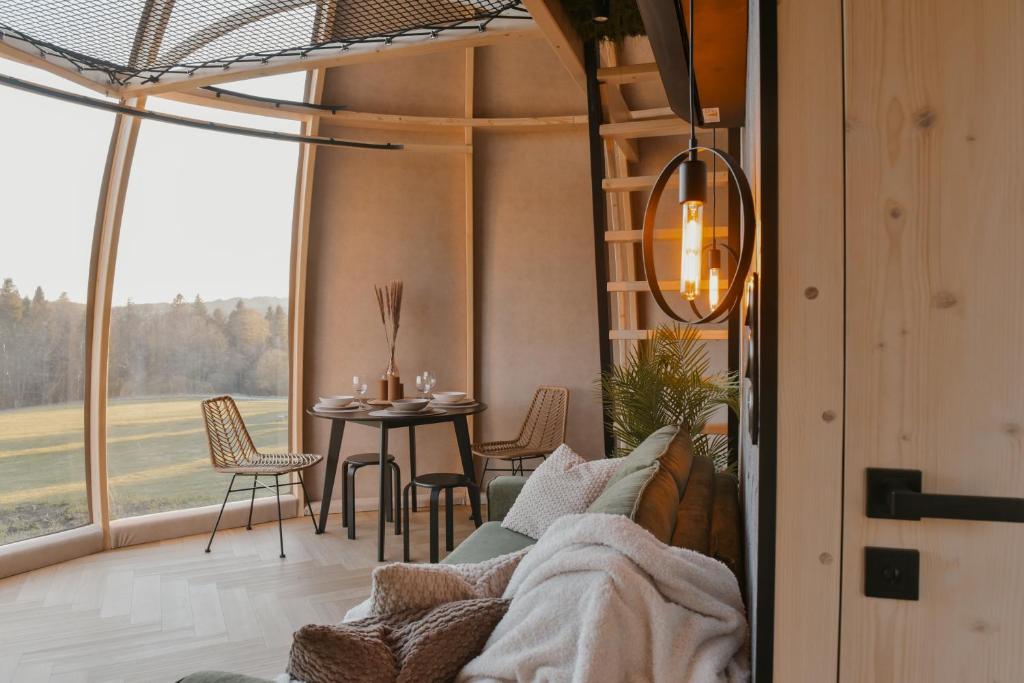 a room with a couch and a table with chairs at AtmoSphere Czorsztyn in Czorsztyn