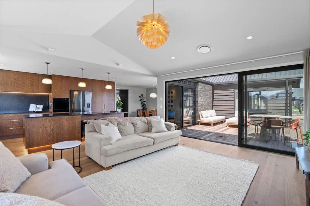 a living room with a white couch and a kitchen at Rua Street Escape in Wanaka