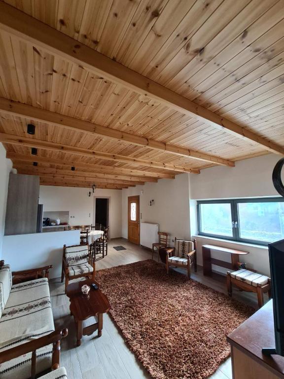 a large living room with wooden ceilings and a large rug at Οκά & δράμι in Kaléntzion
