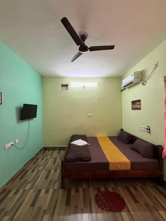 a bedroom with a bed and a ceiling fan at Sunlight Premium in Bhubaneshwar