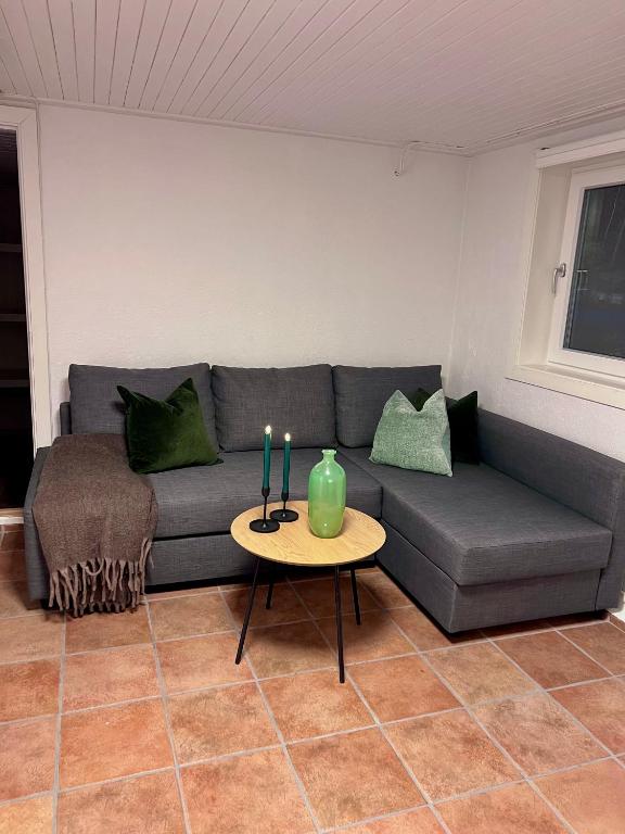 a living room with a couch and a table with candles at Cozy apartment in Drammen