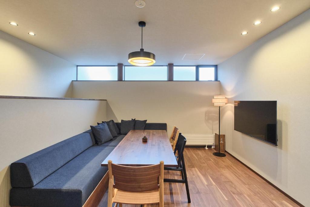 a living room with a couch and a table at Hotel GGG Asahikawa in Asahikawa