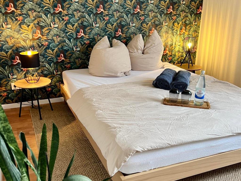 a bedroom with a bed with pillows and a floral wall at Simply Enjoy Ferienwohnungen in Losheim