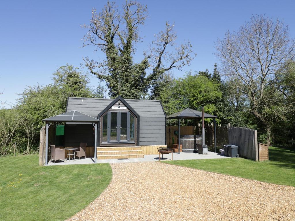 a tiny house in a garden with a gazebo at Acorn Lodge At Bridge Lake Farm & Fishery in Banbury