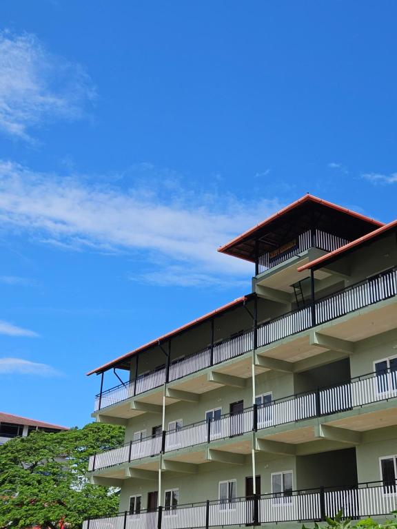 a building with balconies and a blue sky at Chippy Residency Coorg in Gonikoppal