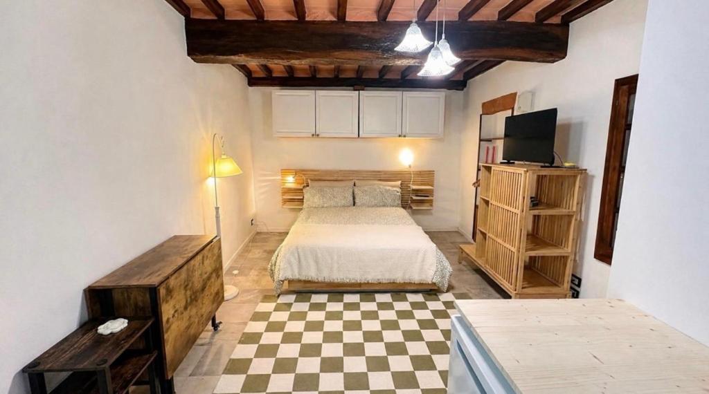 a bedroom with a bed and a checkered floor at La cassetta 22 in Castelnuovo dellʼAbate
