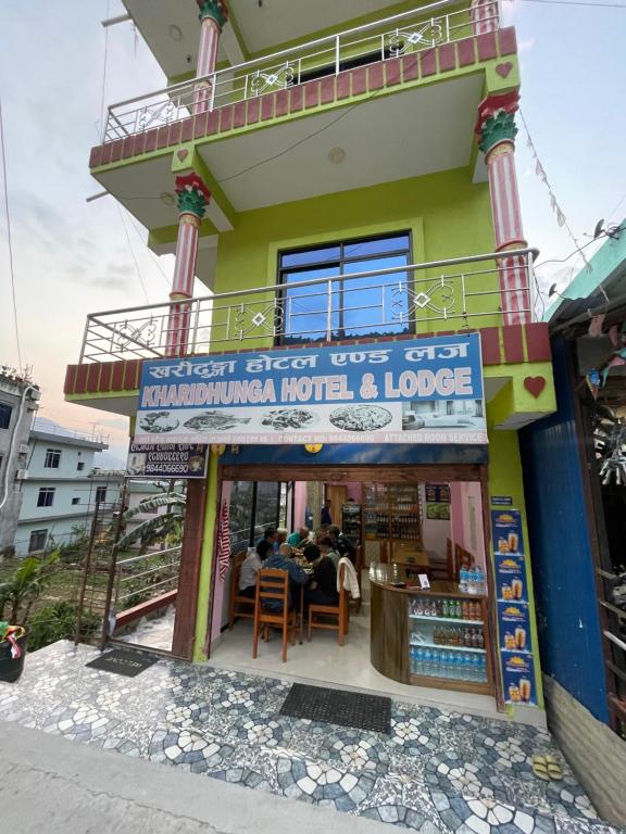 a restaurant with people sitting at a table in front of a building at Kharidhunga hotel and lodge in Rāmechhāp